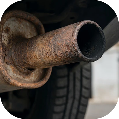 Tubo de escape oxidado bajo un vehículo